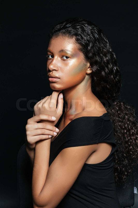 African woman in profile. in t-shirt. isolated black background, stock photo