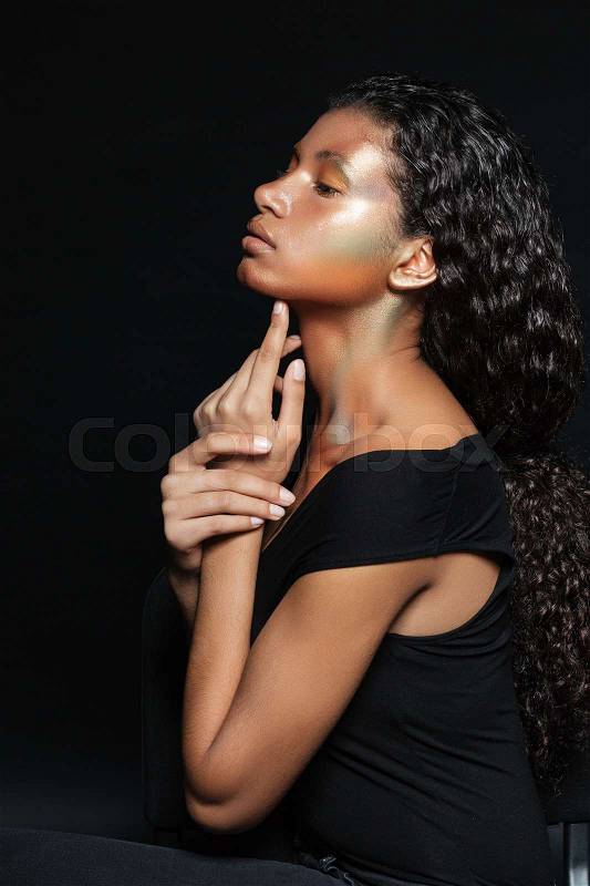 Pretty african woman in profile. in studio. isolated black background, stock photo
