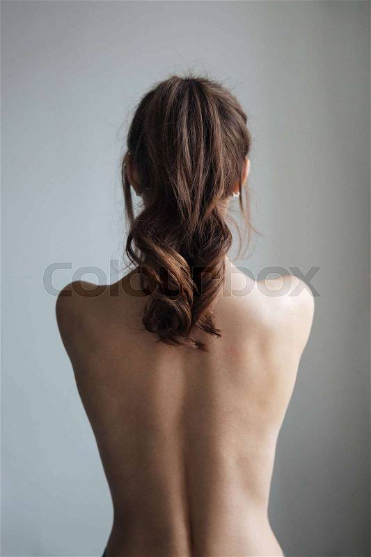 Back view of pretty naked woman. isolated gray background, stock photo