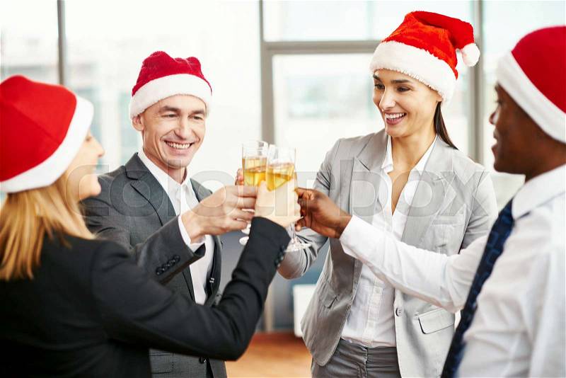 Employees in formalwear cheering up with flutes of champagne, stock photo