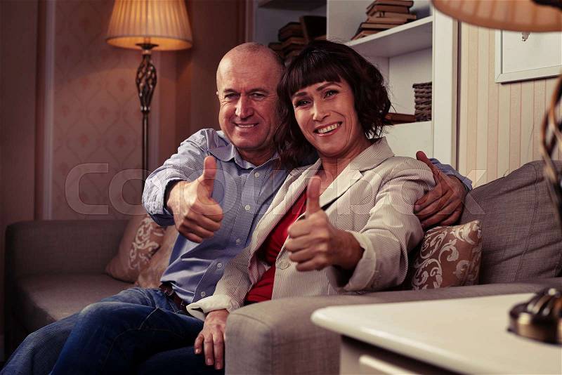 A mid short of two cute people showing their thumbs-up, demonstrating harmony and happiness, loving each other. Individuals wearing mainly classic clothes, stock photo