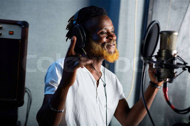 Enthusiastic singer performing and recording modern songs, stock photo