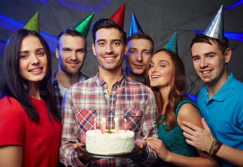 Happy man with birthday cake and his friends, stock photo