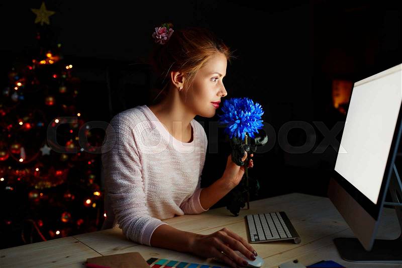 Young designer spending Christmas night in office, stock photo