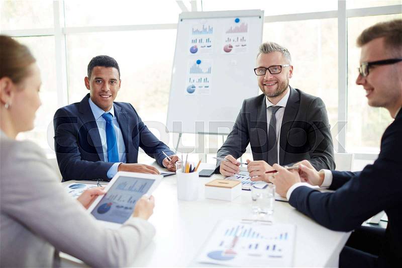 Group of happy specialists analyzing financial data or statistics, stock photo