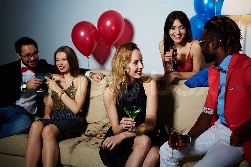 Happy young men and women having party with drinks, stock photo