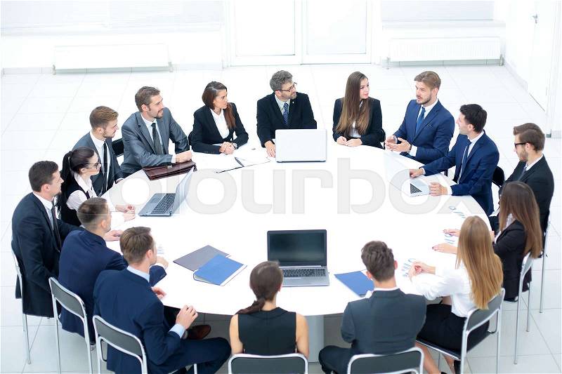 Businesspeople Sitting At Conference Round Table At The Meeting, stock photo