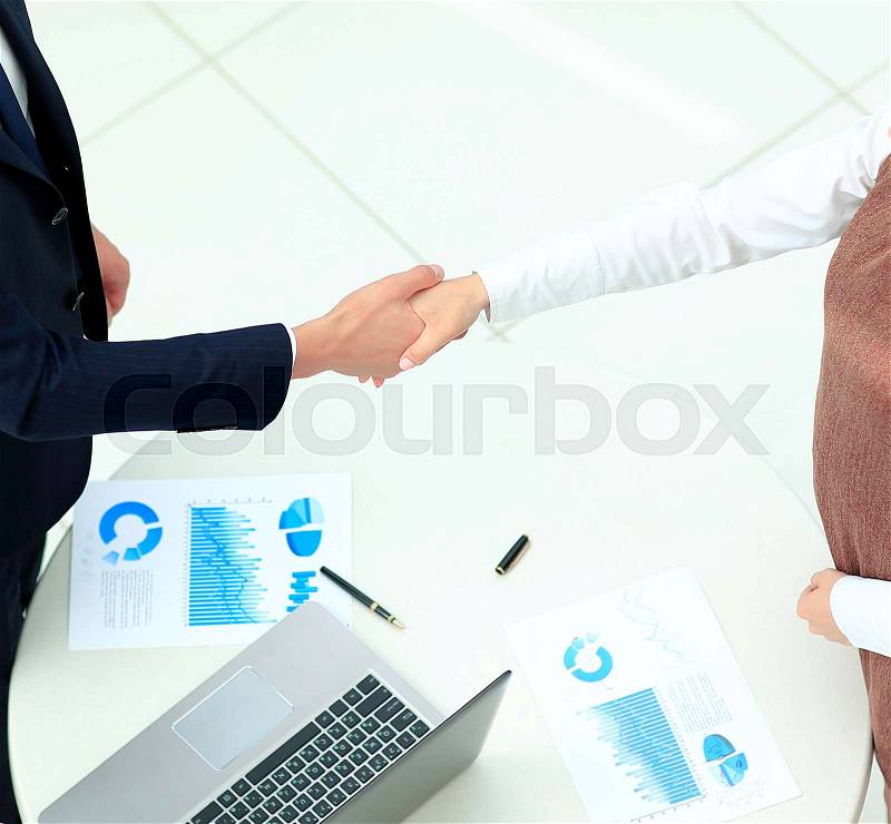 Business partners shaking hands in meeting hall, stock photo