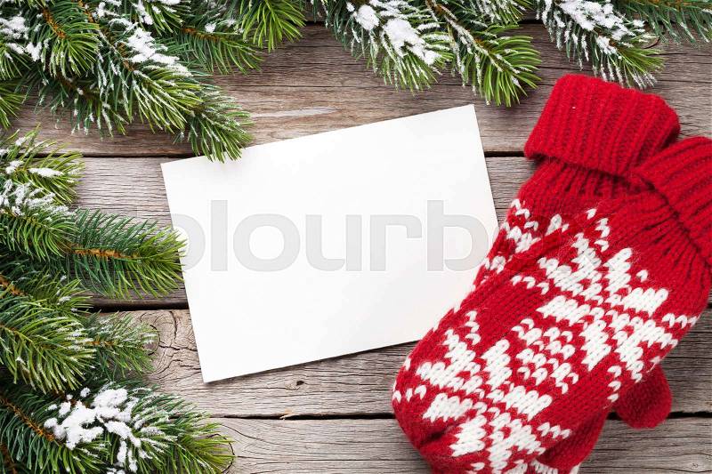 Christmas greeting card, fir tree and mittens on wooden table. Top view with copy space, stock photo