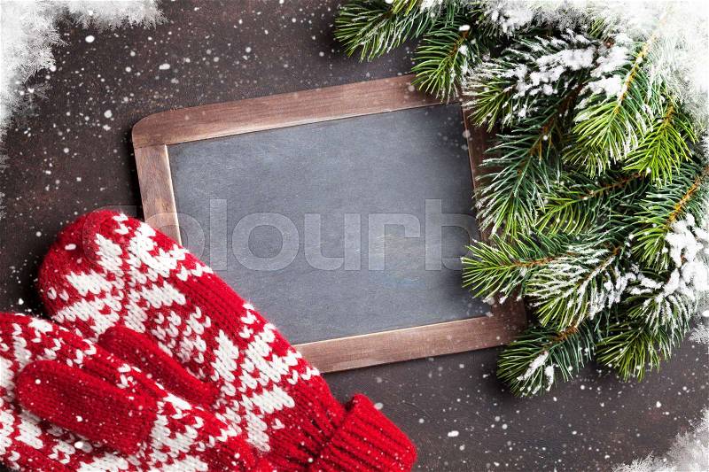 Christmas fir tree, mittens and chalkboard for your greetings. Top view with copyspace, stock photo