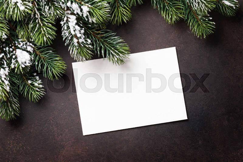 Christmas greeting card and fir tree over stone background. Top view with copy space, stock photo