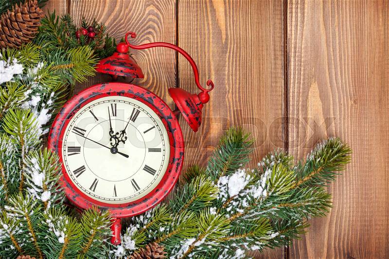 Christmas wooden background with clock, snow fir tree and copy space, stock photo