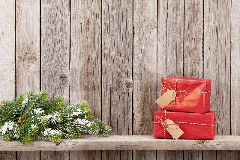 Christmas gift boxes and fir tree toy in front of wooden wall. View with copy space, stock photo