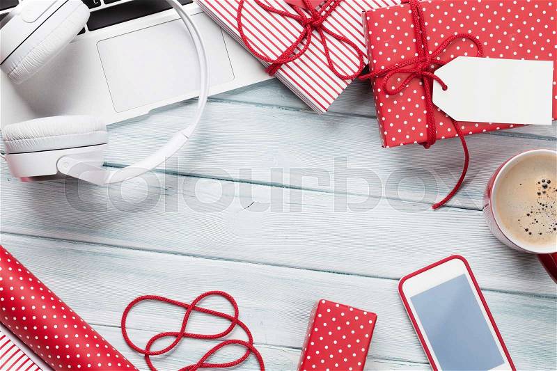 Christmas gift boxes, laptop, headphones and coffee cup on wooden background. Top view with copy space for your text, stock photo