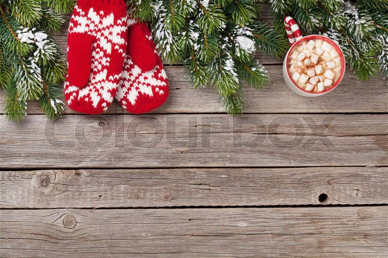 Christmas background with fir tree, mittens, hot chocolate and marshmallow on wooden table. Top view with copy space, stock photo