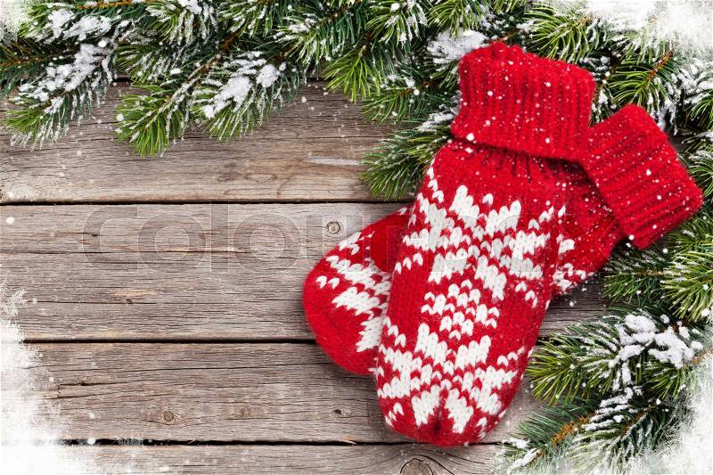 Christmas wooden background with fir tree and mittens. Top view with copy space, stock photo