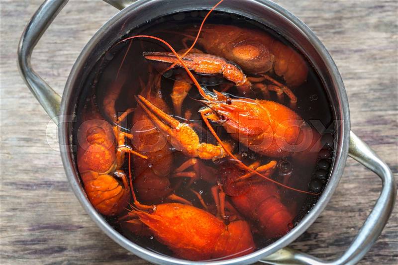 Pot with boiled crayfish on the wooden table, stock photo