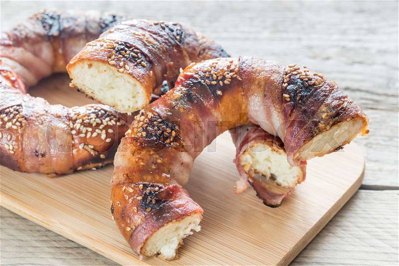 Bagels with sesame wrapped in bacon rashers, stock photo