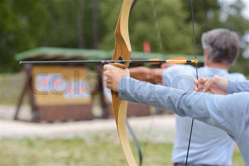 Man and woman practicing archery, stock photo