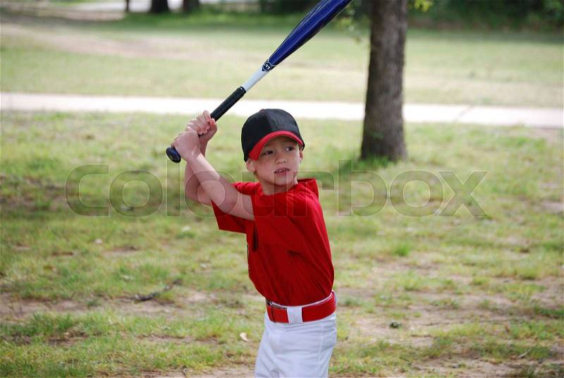 Portrait of Little baseball player holding bat wearing jersey, stock photo
