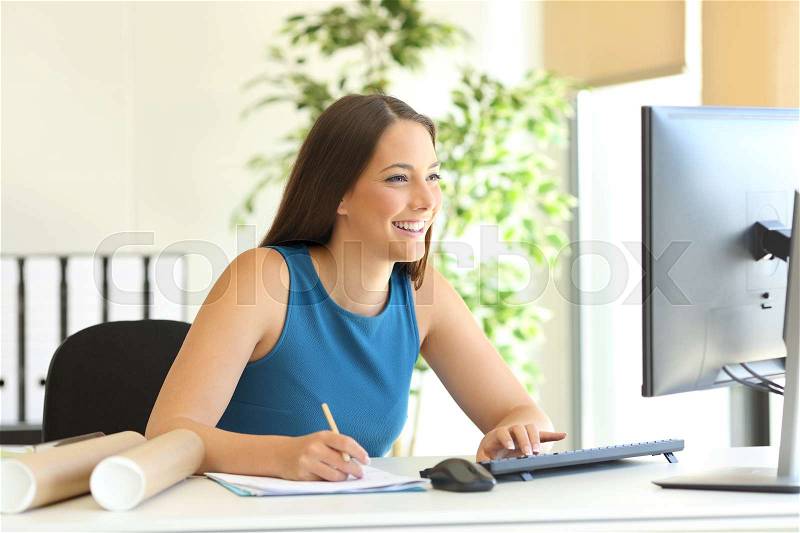 Happy businesswoman working on line with a computer and taking notes at office, stock photo