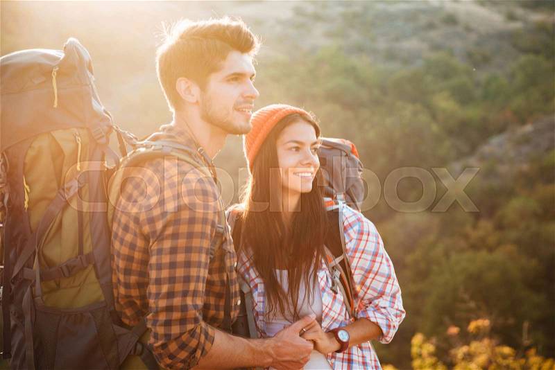 Two tourists on slope in profile. stands sideways, stock photo