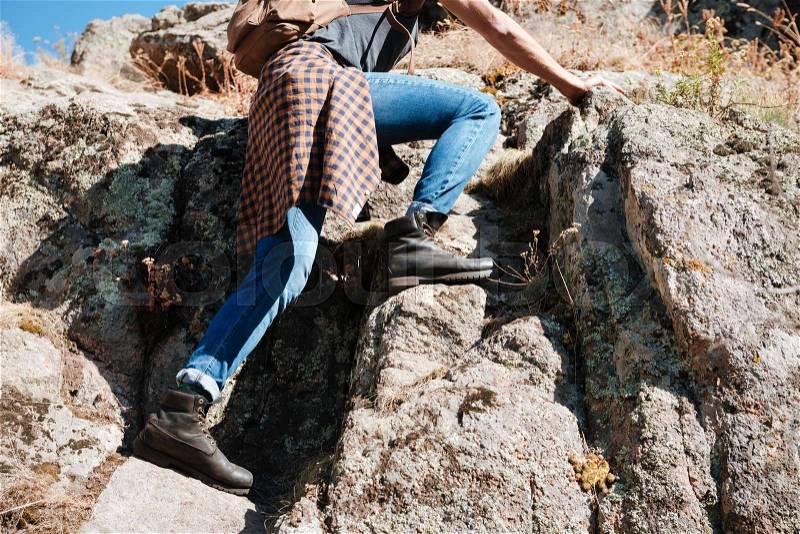Cropped image of a young male hiker climbing mountains, stock photo