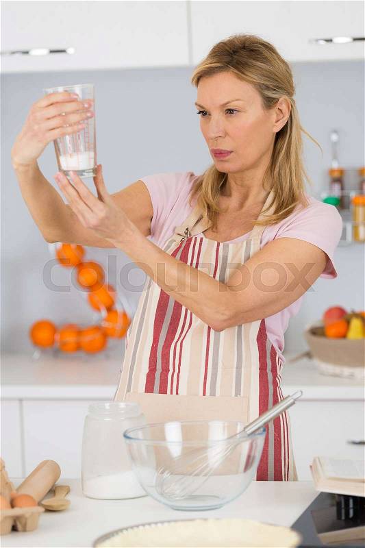 Woman cook measuring sugar for cake recipe, stock photo