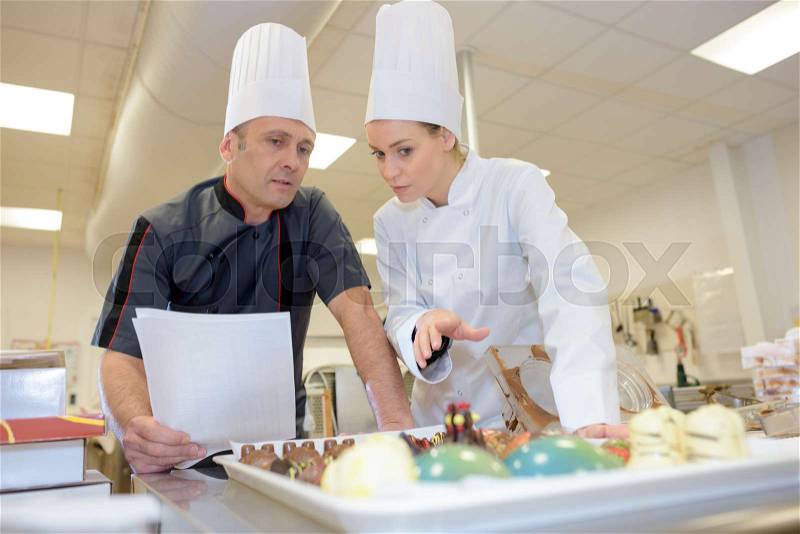 Chef team in restaurant kitchen with dessert, stock photo