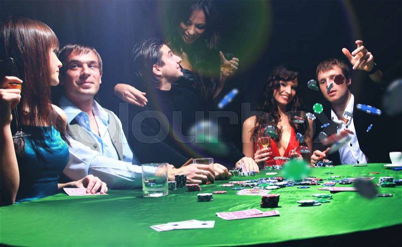 Poker players sitting around a table at a casino, stock photo