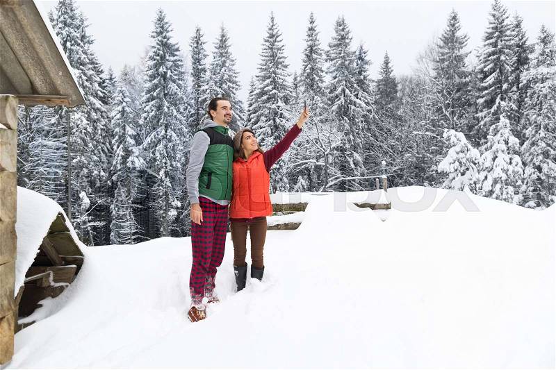 Couple Taking Selfie Photo On Smart Phone Snowy Village Wooden Country House Man Woman Winter Snow Resort Cottage, stock photo