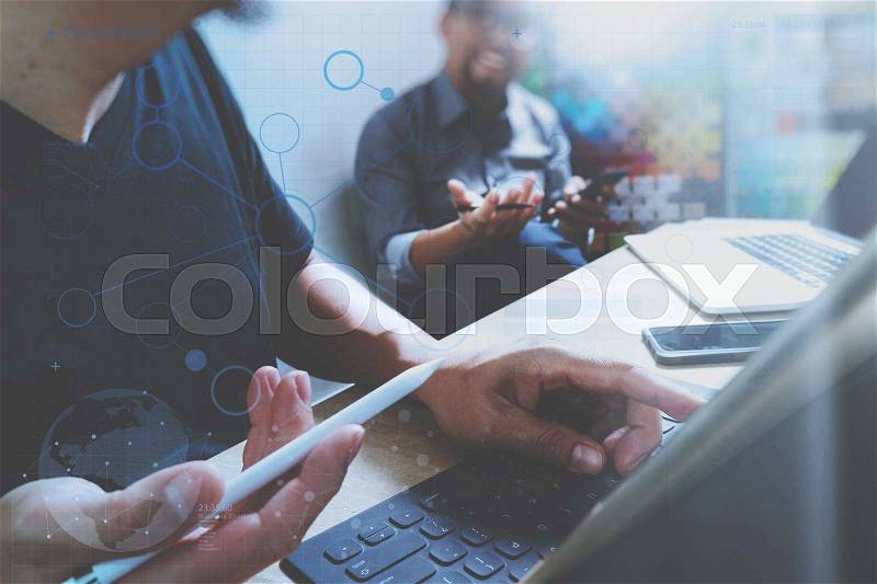 Coworking process, entrepreneur team working in creative office space. using digital tablet docking keybord and laptop with smartphone on marble desk,light beam effect, stock photo
