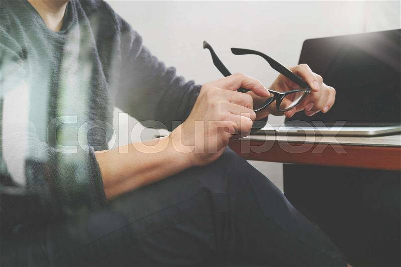 Website designer holding eyeglass working computer laptop on wood table,filter effect , stock photo