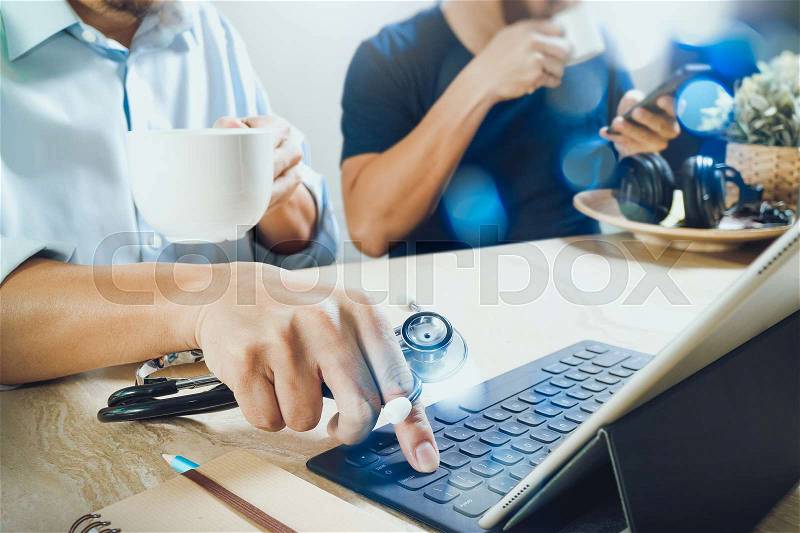 Medical doctor team taking coffee break.using digital tablet docking smart keyboard and smart phone on marble desk.listen music,filter film effect, stock photo