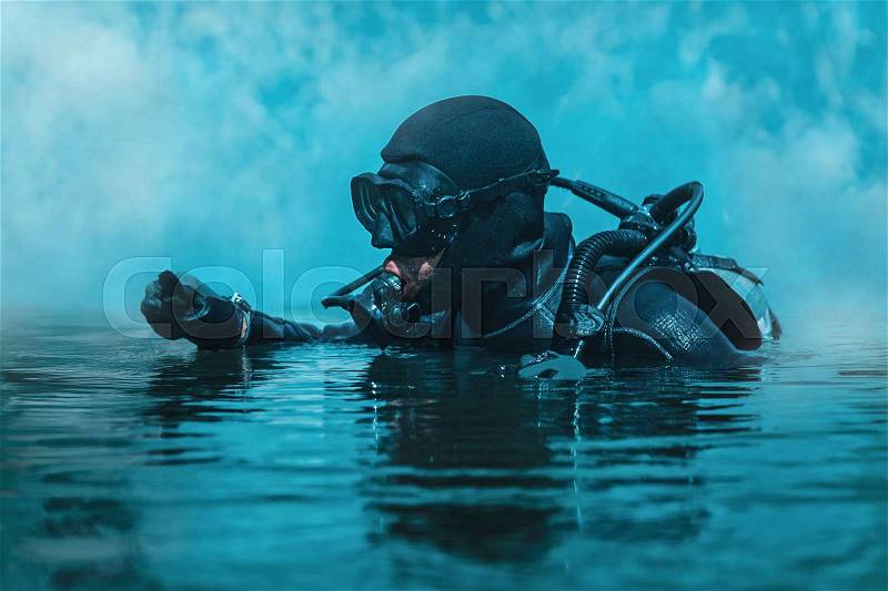 Navy SEAL frogman with complete diving gear and weapons in the water, stock photo