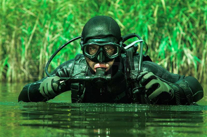Navy SEAL frogman with complete diving gear and weapons in the water, stock photo