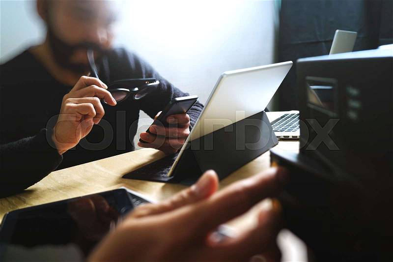 Co working process, entrepreneur team working in creative office space. using digital tablet docking keyboard and laptop with smart phone on marble desk,light beam effect, stock photo