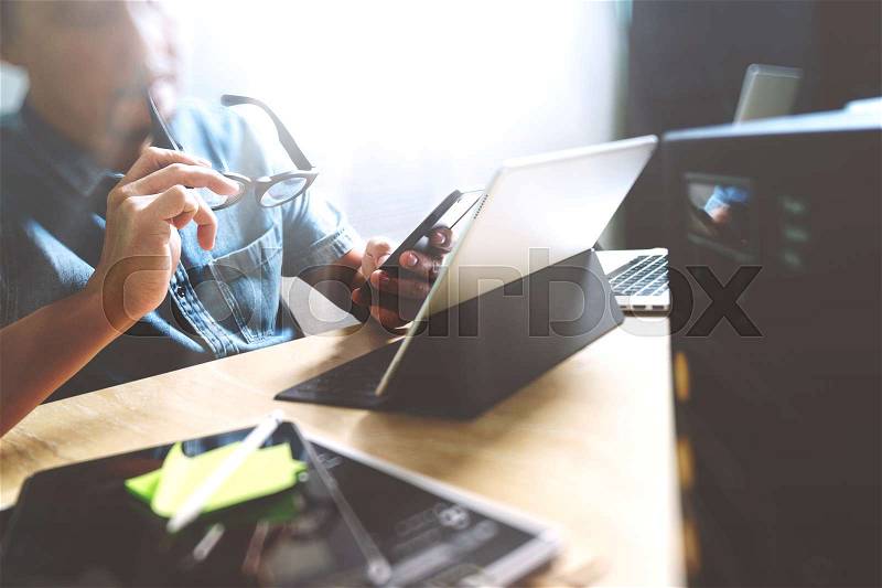 Website designer working digital tablet and computer laptop with digital tablet and digital design diagram on wooden desk and compact server, stock photo