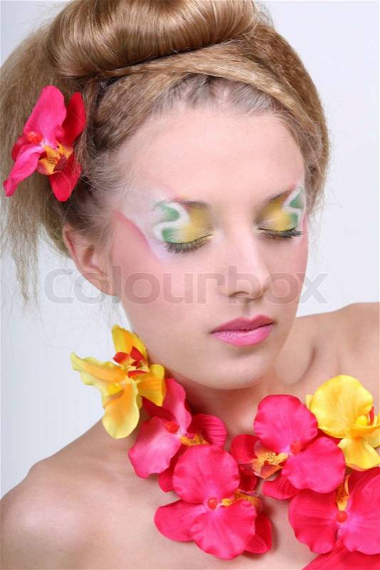 Beautiful woman with creative make-up, coiffure and flowers, stock photo