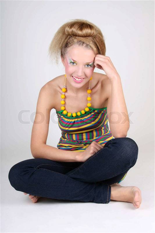 Young woman with creative make-up and coiffure sitting, stock photo