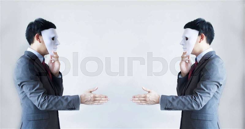 Two men in business suit handshaking with masks on - Business fraud and hypocrite agreement, stock photo