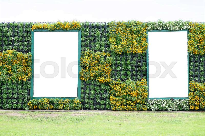 Blank billboard in vertical tropical garden with various kind of green plants and flowers, stock photo