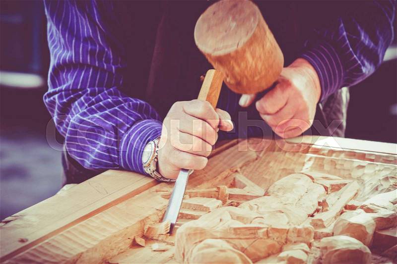 Hands of the craftsman carve a bas-relief with a gouge. Craftsman hands working. Work Of Artist, stock photo