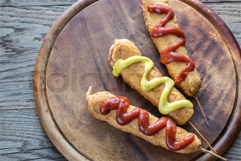 Corn dogs on the wooden board, stock photo