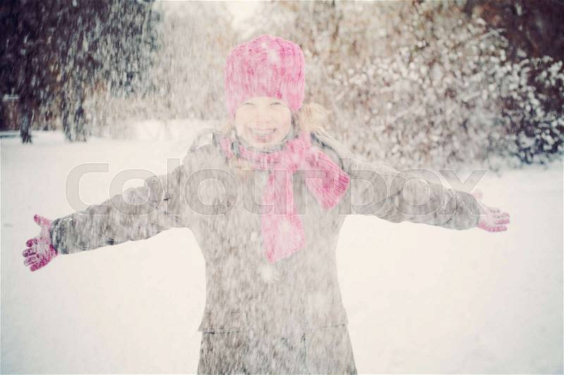 Happy Child Girl Having Fun Playing with Snow in Snowy Winter Day Outdoors, stock photo