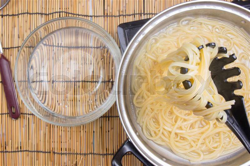 Spaghetti lifted on of cold water / cooking spicy spaghetti concept, stock photo