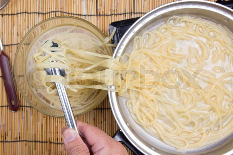 Spaghetti lifted on of cold water with tomgs / cooking spicy spaghetti concept, stock photo