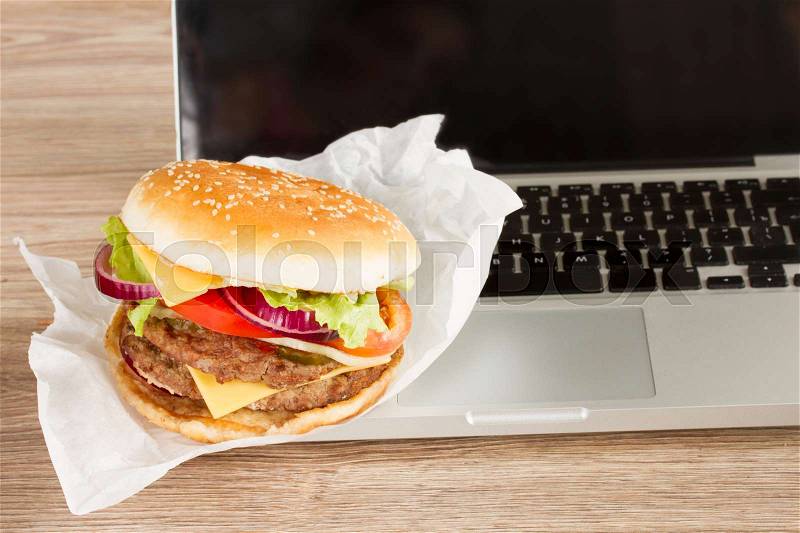 Lunch at work place fast food near laptop, stock photo