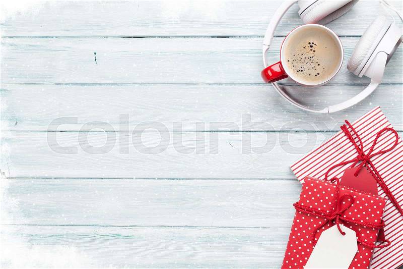 Christmas background with gift boxes, coffee cup and music headphones on wooden table. Top view with copy space, stock photo