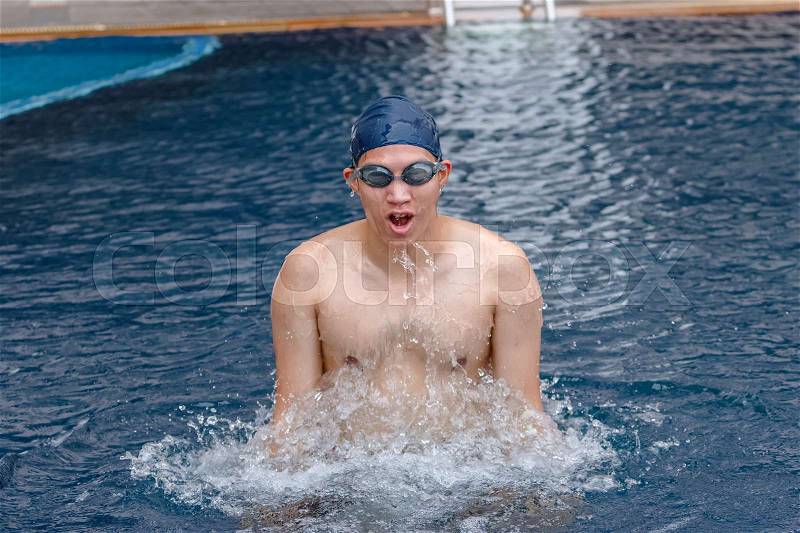 Young man finishing swimming training, getting out of pool, stock photo